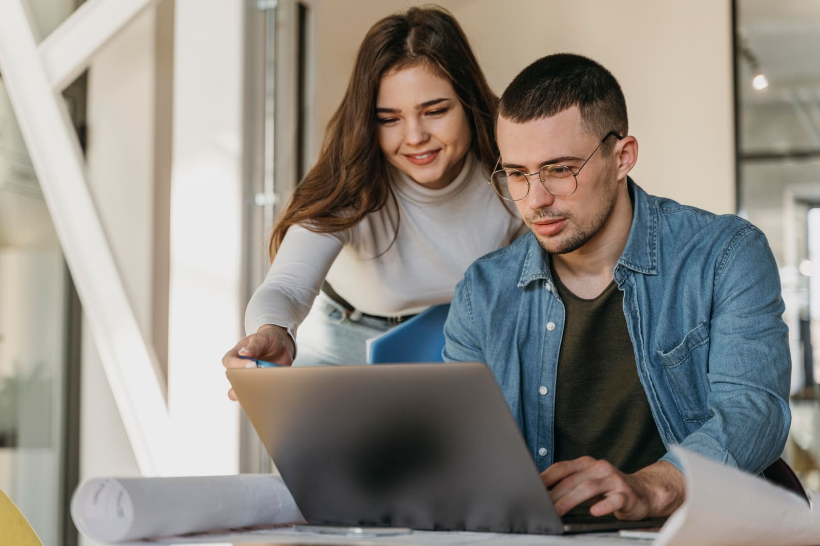 Two colleagues reviewing data on a laptop